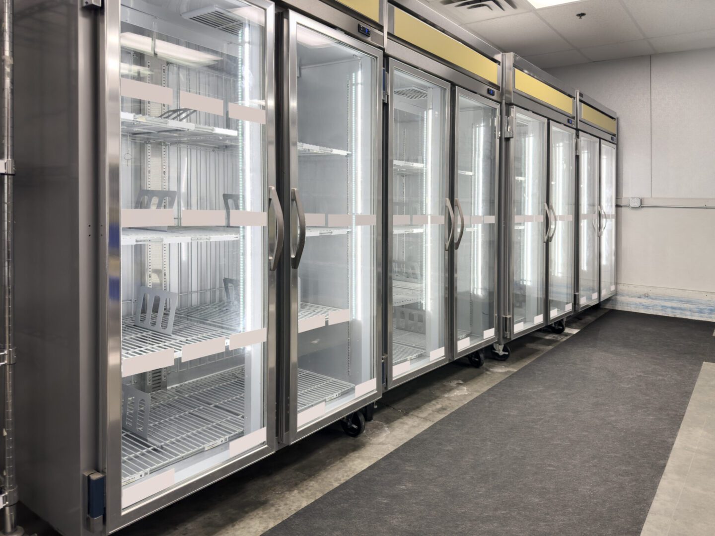 Empty market displays A row of refrigerators in an empty room.