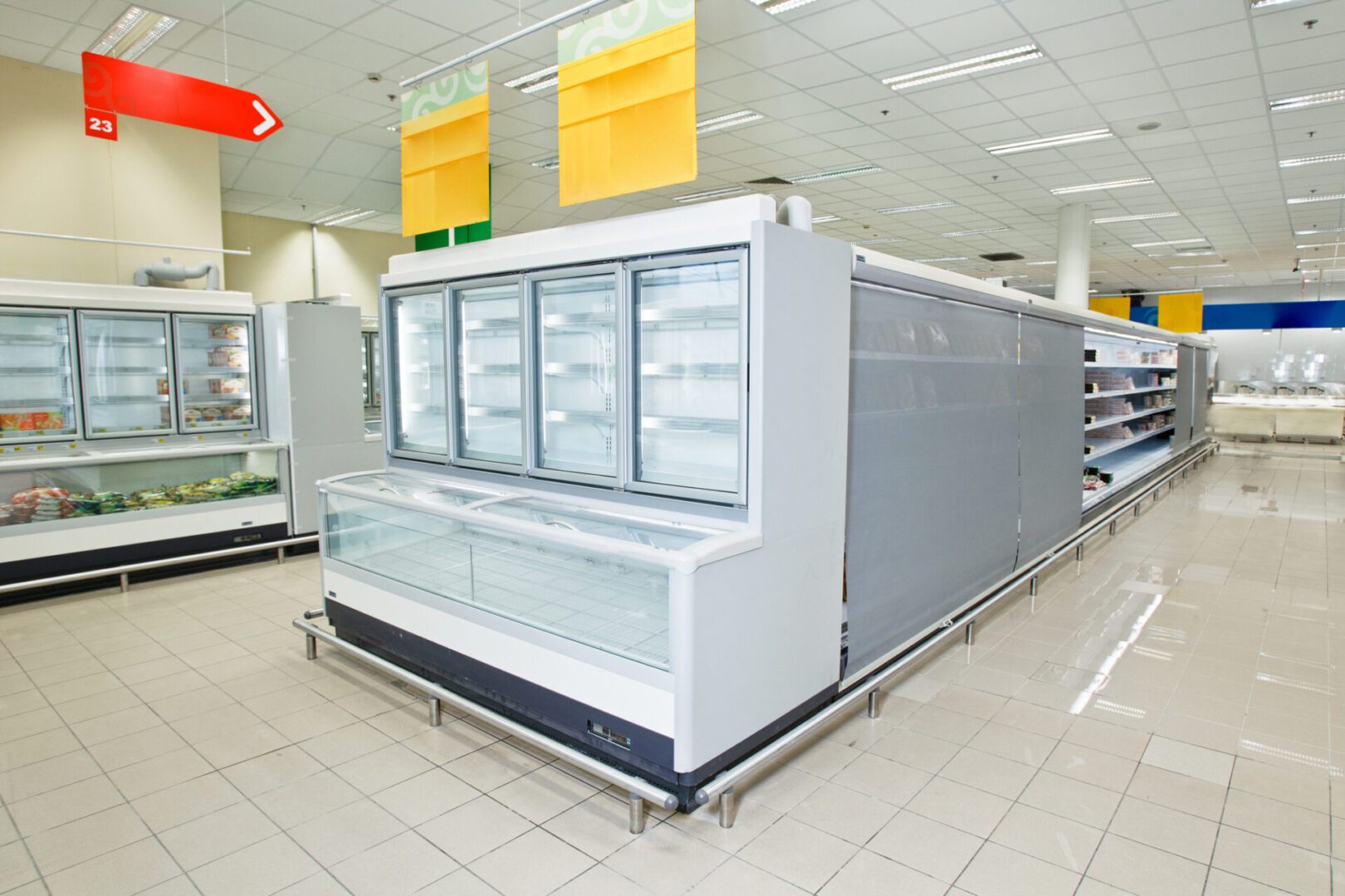 A store with refrigerators and shelves in it